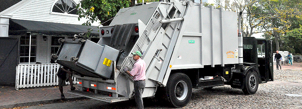Reis Trucking commercial packer truck servicing a dumpster